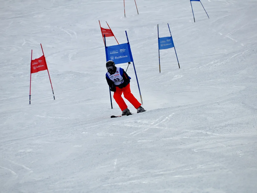 Skifahrer in roter Hose zwischen den Toren.